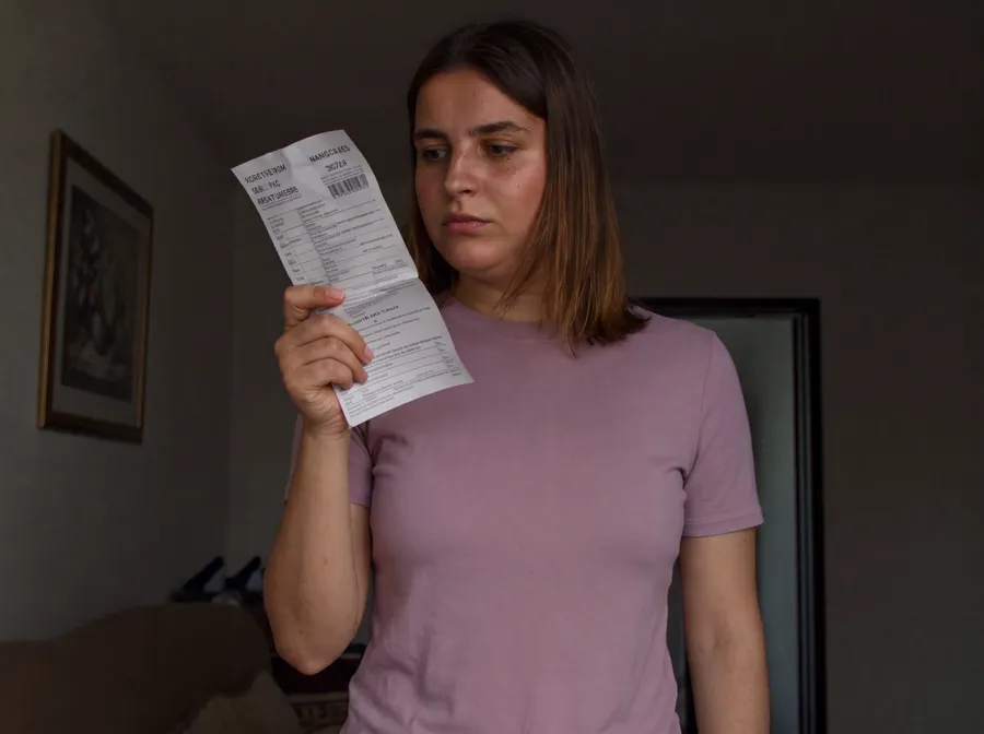 Pessoa em casa no escuro segurando a conta durante um corte de serviço